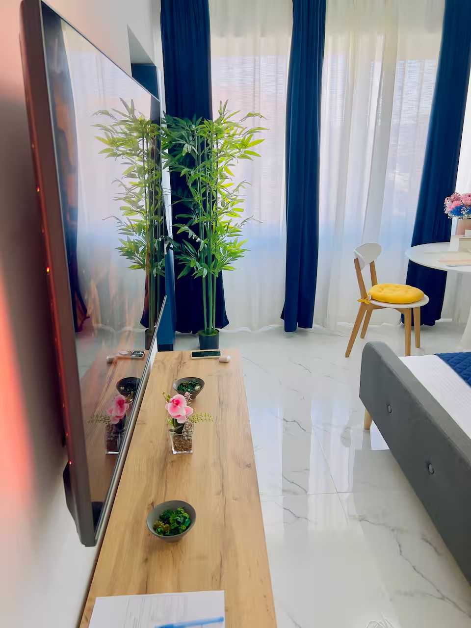 O cameră cu un pat, o masă, un scaun, o plantă de oală și un televizor — studio în Pitesti