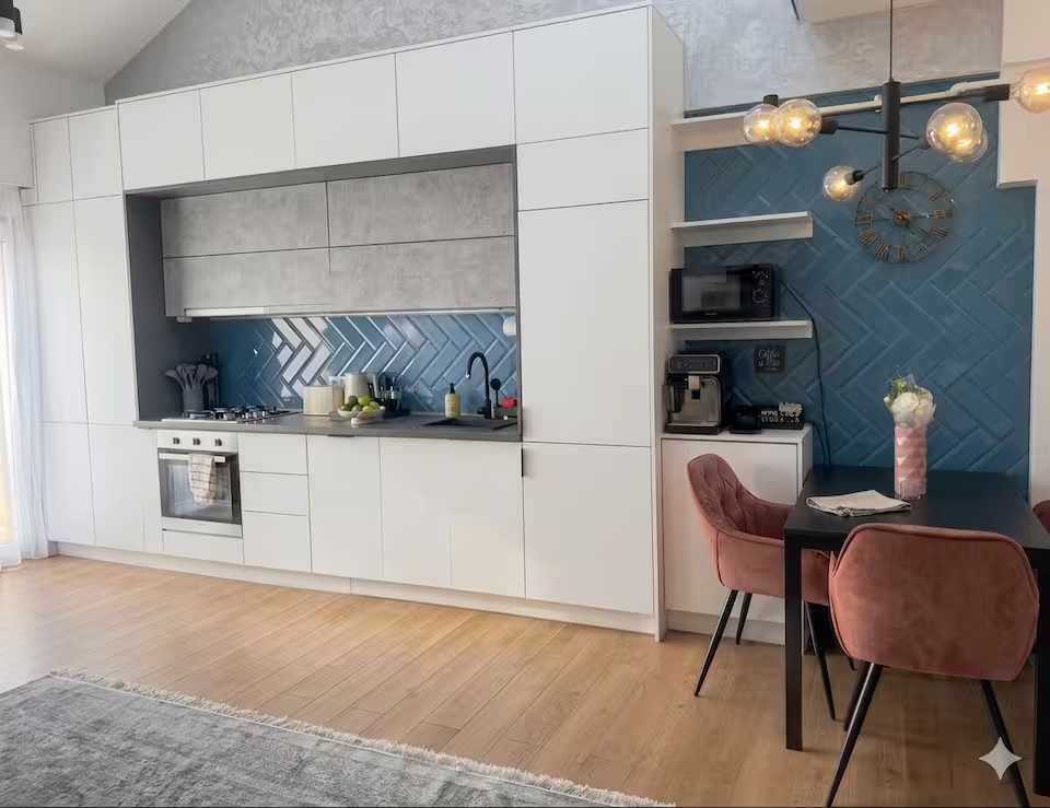 O bucătărie cu masă și scaune — apartament în Oradea