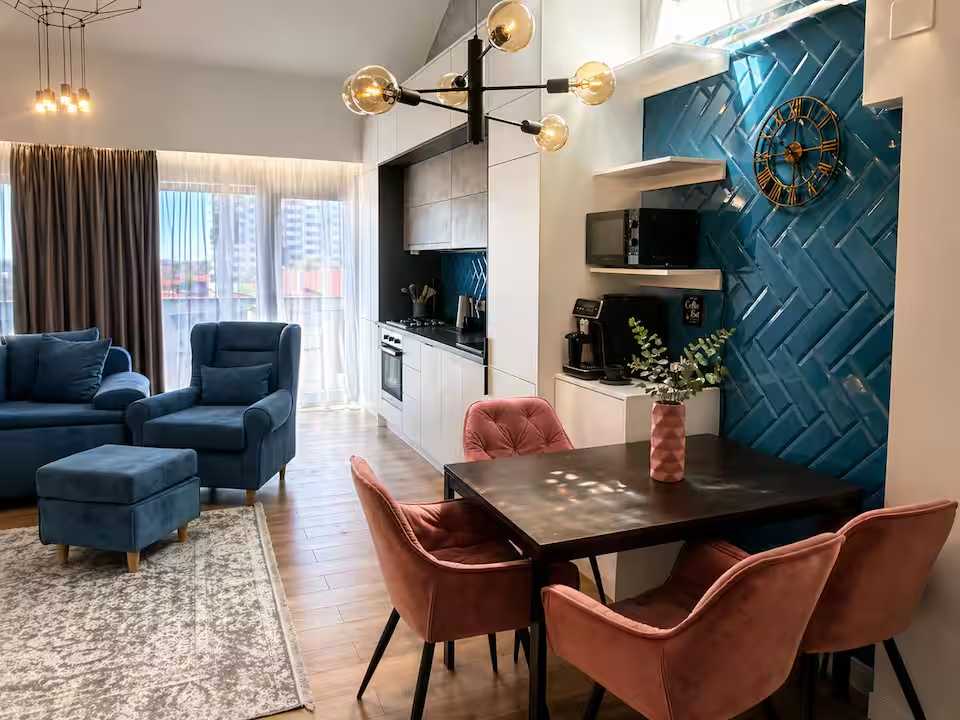 O cameră de zi cu masă, scaune și o fereastră — apartament în Oradea