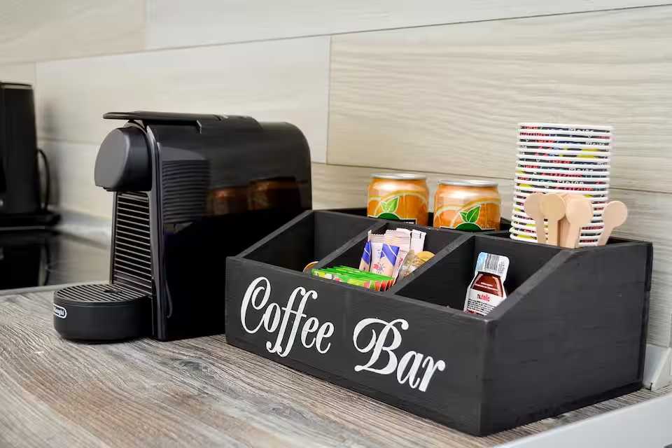 Un bar de cafea negru cu o mașină de cafea și cutii de cafea — studio în Oradea