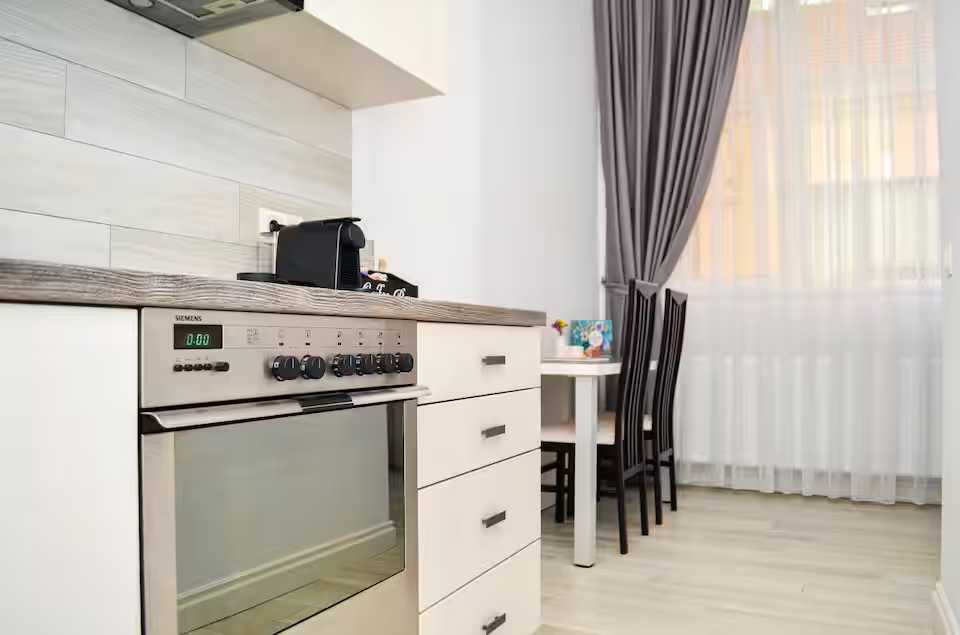 O bucătărie cu un cuptor și o masă — studio în Oradea