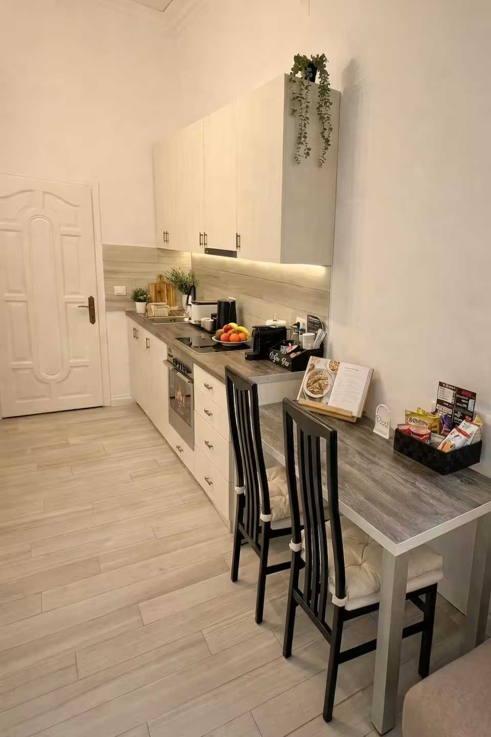 O bucătărie albă cu masă și scaune — studio în Oradea