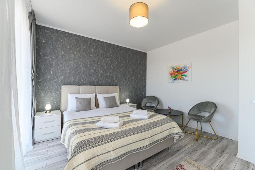O cameră cu un pat, un scaun și o lampă — apartament în Brașov