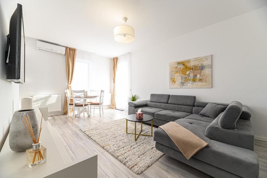 O cameră de zi cu canapea, masă și scaun — apartament în Brașov