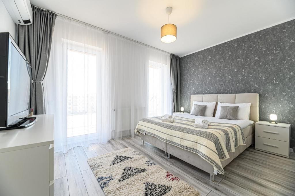 O cameră cu un pat, o lampă și o fereastră — apartament în Brașov