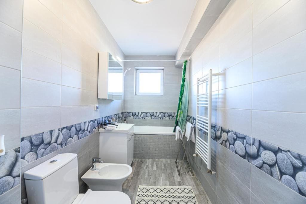 O baie cu toaletă, chiuvetă și duș — apartament în Brașov