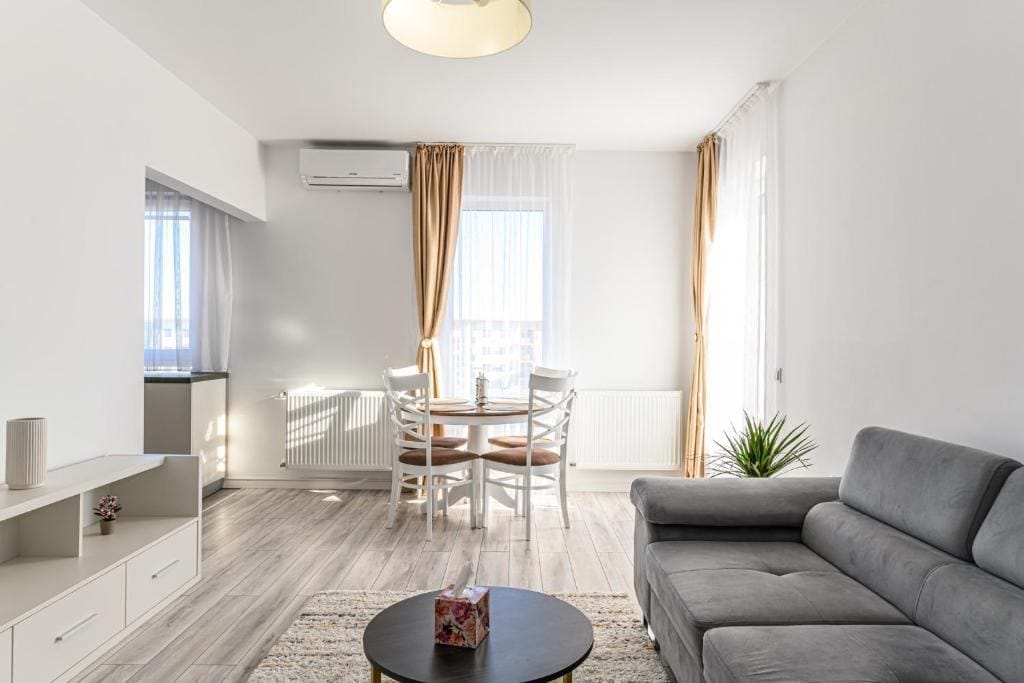 O cameră de zi cu canapea, masă și fereastră — apartament în Brașov