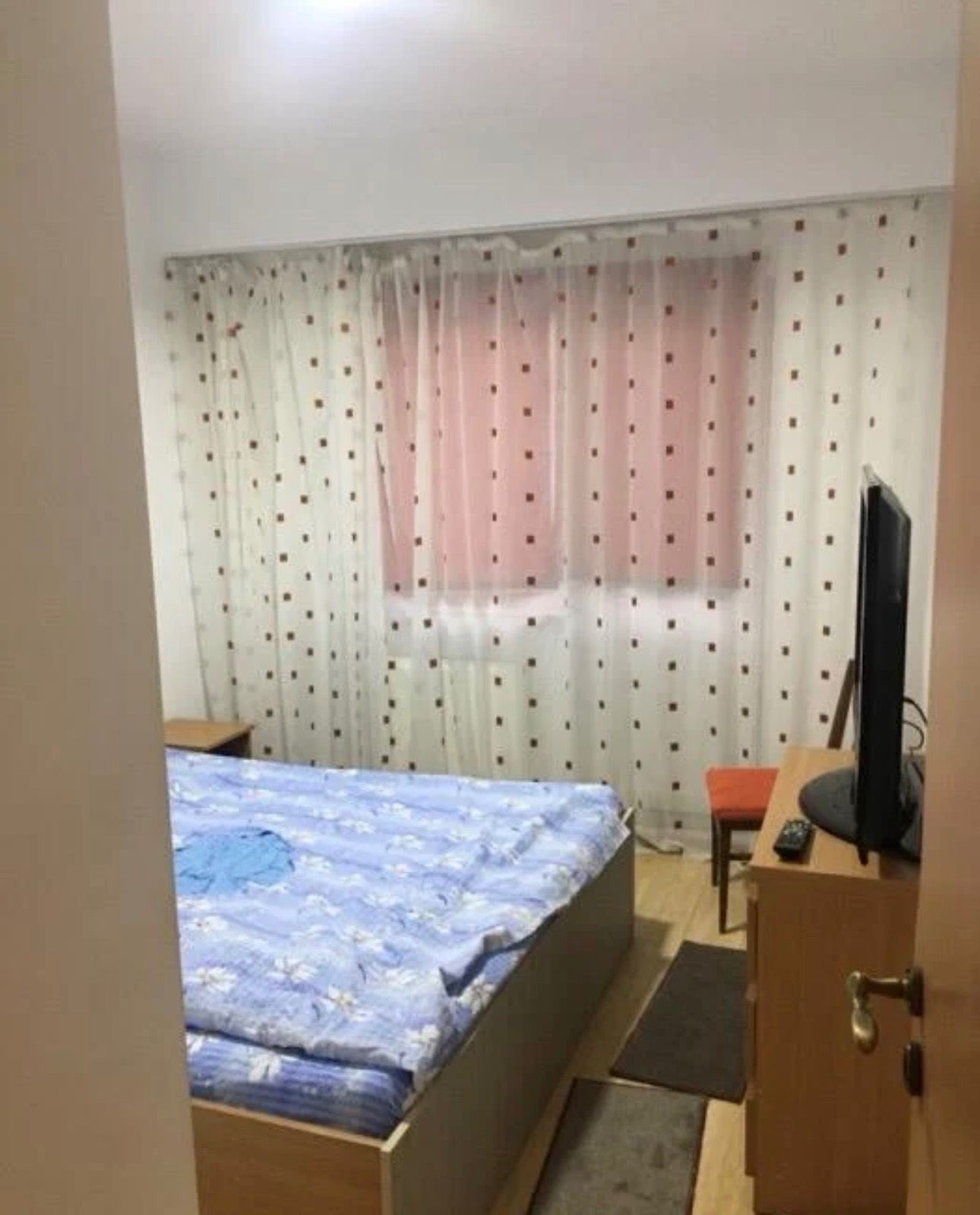 O cameră cu un pat, un scaun și un televizor