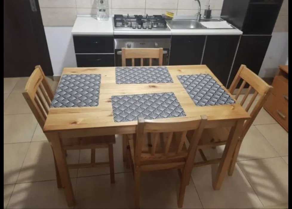 O bucătărie cu o masă din lemn și scaune