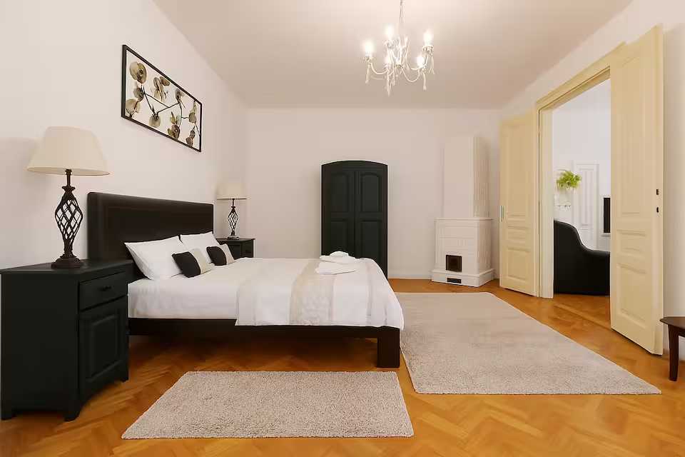 O cameră cu un pat, un dulap și un candelabru — apartament în Oradea