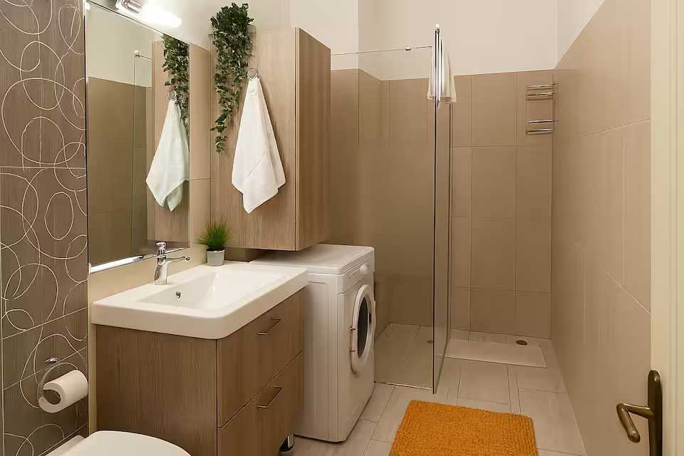 O baie mică cu chiuvetă și o mașină de spălat și uscat — apartament în Oradea