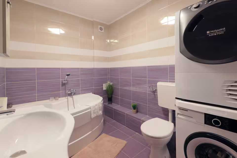 O baie cu toaletă, chiuvetă și canapea — apartament în Oradea