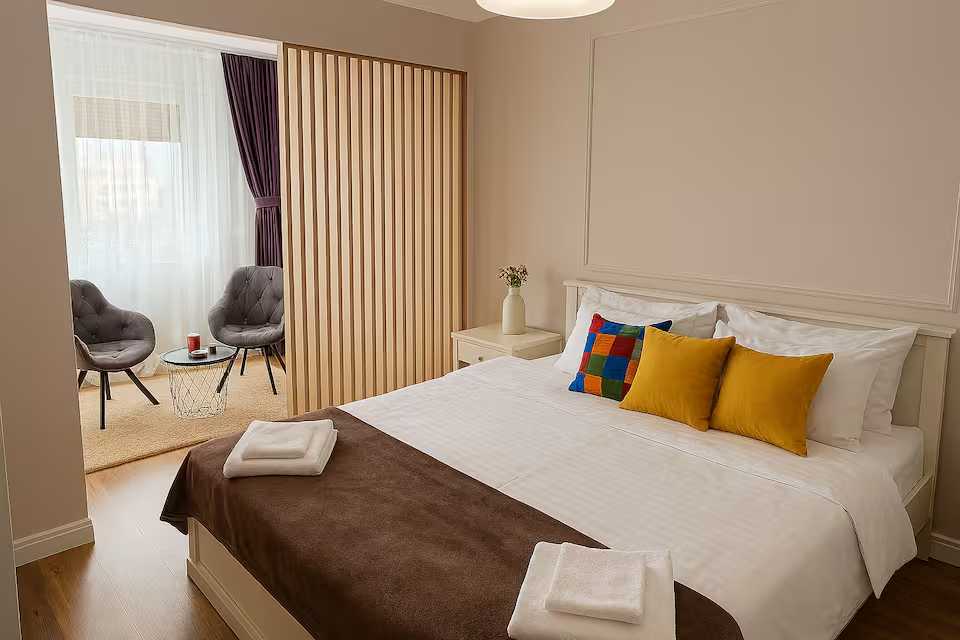 O cameră cu un pat, un scaun și o fereastră — apartament în Oradea