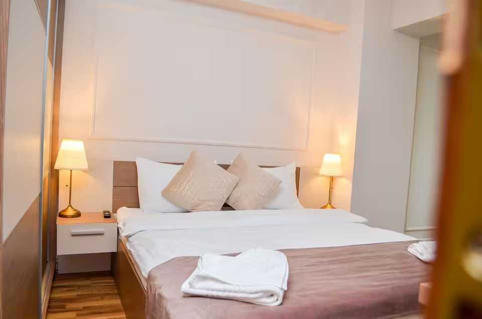 O cameră cu un pat și o lampă — apartament în Oradea